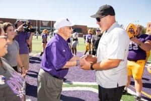 Coach Keeling handing Coach Burleson the game ball